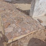 Integración de barda perimetral de piedra laja pegada con mortero cal-arena