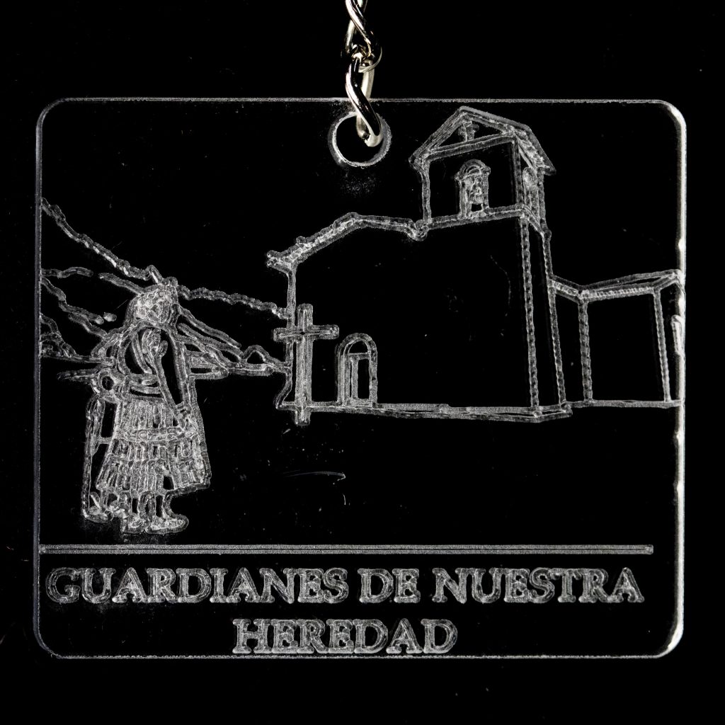 Llavero con un edificio y una figura y el texto "Guardianes de nuestra heredad"